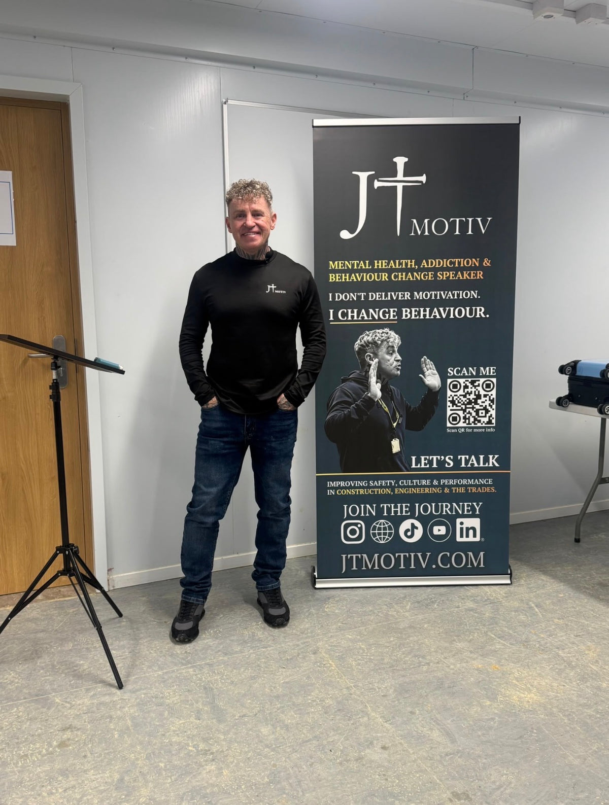 James Ford of JT MOTIV standing beside the JT MOTIV banner