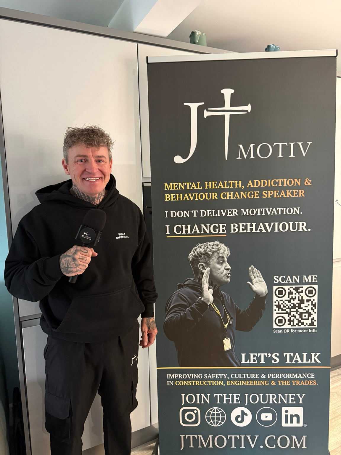 James Ford with microphone beside JT MOTIV banner