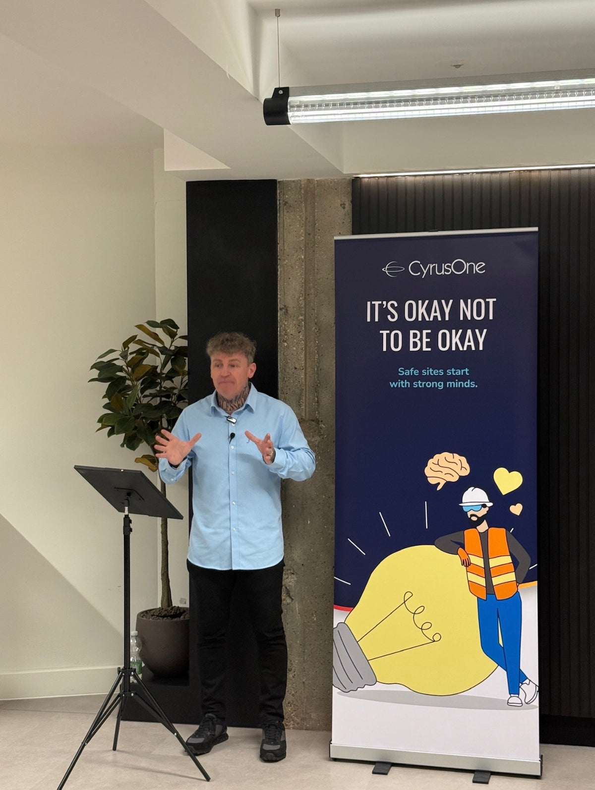 James Ford of JT MOTIV speaking beside the CyrusOne mental health safety banner